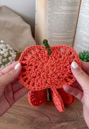 Hands holding a pumpkin coaster